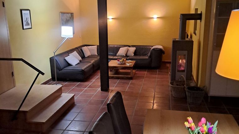 Ein gemütliches Wohnzimmer mit moderner Einrichtung und einer großen Couch. Der Raum ist hell erleuchtet und hat eine einladende Atmosphäre.